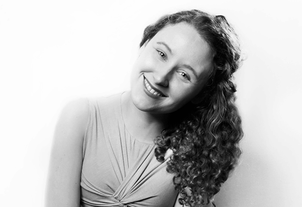 black and white headshot photo of person tilting her head to the right 